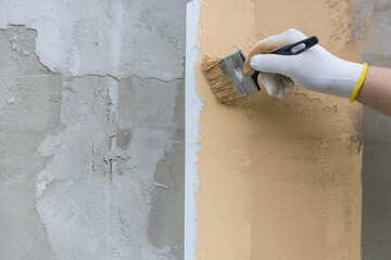 A person is painting a wall with a brush