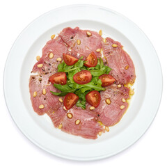 cooking tuna carpaccio - Fresh raw tuna fillet with olive oil and pine nuts on white ceramic plate