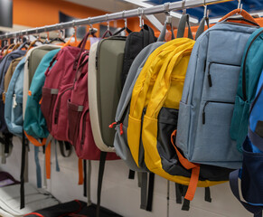 A row of backpacks hanging on a rack