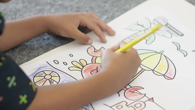 A child draws with a colored pencil in an album. Children's creativity, learning in kindergarten, school or at home. Pencil close up, selective focus. Color the picture.