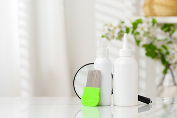 Green Comb on a Countertop with Lice Treatment Products
