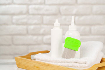 Bottles of Lice Treatment Products and a Comb on a Countertop