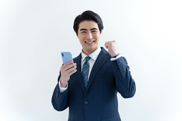 携帯を持ちカメラ目線で悩むスーツを着た日本人男性