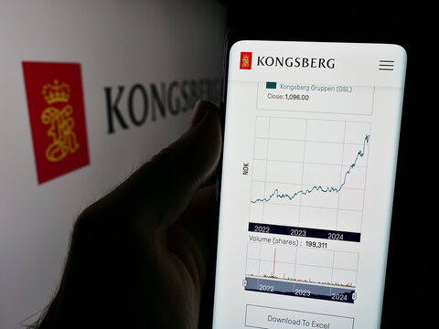 Stuttgart, Germany - 08-20-2024: Person holding cellphone with webpage of Norwegian company Kongsberg Gruppen ASA in front of logo. Focus on center of phone display.
