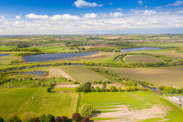 Naklejka premium Aerial country side photo of a beautiful spring time scenic view with blue sky and fluffy white clouds located in the village of Castleford in Wakefield West Yorkshire in the UK