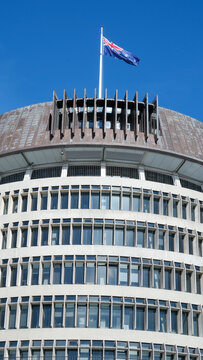 Close up exterior view of The Beehive parliamentary building with New Zealand flag flying on top in capital city of Wellington, New Zealand Aotearoa - taken on 28th August 2024