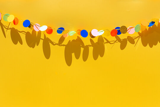 Colorful birthday garland against yellow background