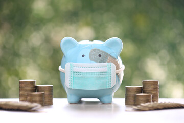 Piggy bank attached to the plaster on the head and stack of coins money on green background, Save money for Medical insurance and Health care concept