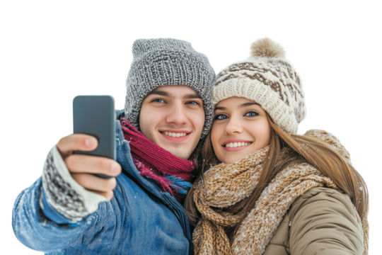 Happy young white couple wearing warm clothes and knitted hats taking a selfie during winter trip holidays, isolated on transparent background, png