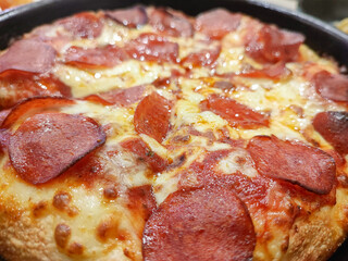 Ham cheese pizza stretches on a tray ready to serve.