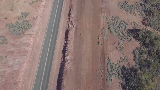 Aerial view of road train on Stuart Highway through rugged desert landscape, Wilora, Australia.