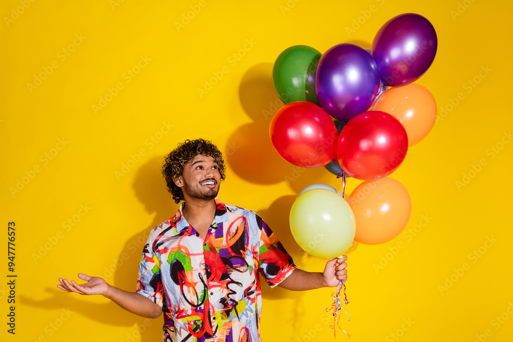 Poster Photo portrait of handsome young male hold look air balloons dressed stylish colorful garment isolated on yellow color background