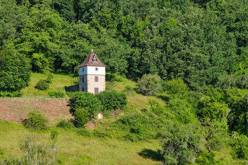 Fototapeta premium Small tower-like house in the green mountains near Autoire Lot Occitanie in Southern France in summer on a sunny day.
