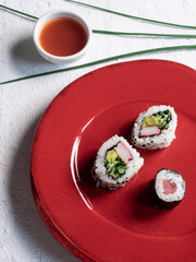 Cibo sushi giapponese. Maki e uramaki su tavolo rosso e sfondo bianco. Vista dall'alto