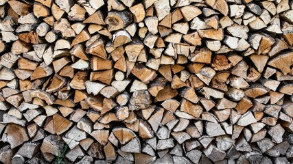 Stacked stack of firewood. Large woodpile with chopped wood. Stacked stack of firewood from the end