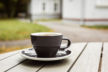 A cup of black coffee on the table of a cafe or bakery terrace