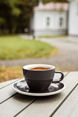 A cup of black coffee on the table of a cafe or bakery terrace