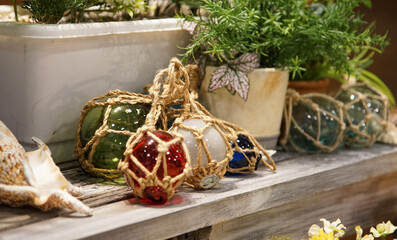 Green leaves of houseplants in the garden and glass ball ornaments on shelves