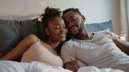 Obraz premium A man and a woman are lying on a bed, smiling at each other