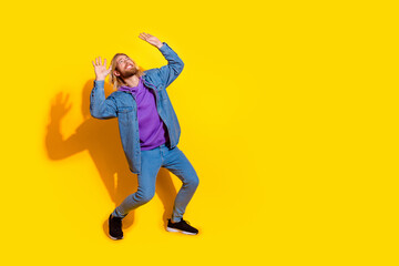 Fototapeta premium Full size photo of nice young man arms hold protect up empty space wear denim jacket isolated on yellow color background