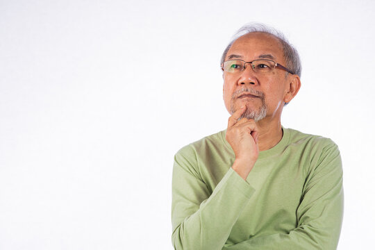 Portrait Asian grey haired with glasses senior man face thinking about something studio shot isolated on white background, elderly with a thoughtful expression holds chin thinking about question