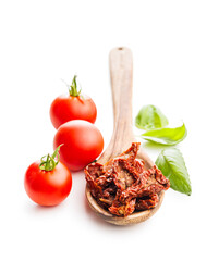 Sun dried red tomatoes on wooden spoon isolated on white background.