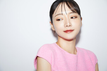 Fototapeta premium 白背景で撮影をした若い女性のカジュアルなメイクアップイメージ