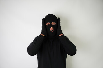 Shocked Young Adult black masked robber with gloves. Isolated over white background.