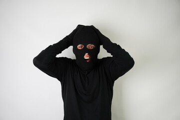 Shocked Young Adult black masked robber with gloves. Isolated over white background.