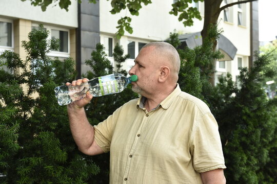 A man drinking water from a bottle in the summer
