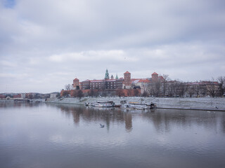 snowy cathedral and calm river in krakow old city