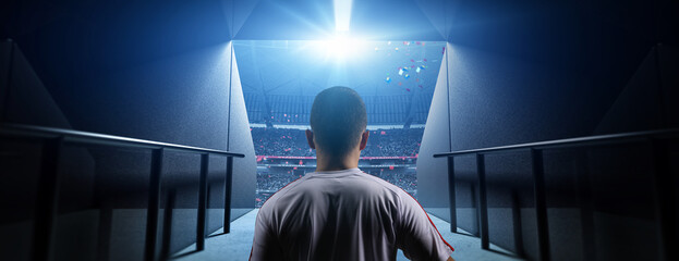 Soccer player entering stadium tunnel before match. Background is an imaginary stadium that is...