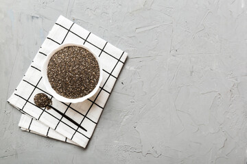 Chia seeds in bowl and spoon on colored background. Healthy Salvia hispanica in small bowl. Healthy superfood