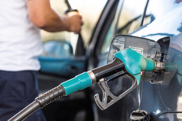 The gas station. Filling the car with gasoline. A Russian fuel dispenser in the fuel tank of a car at a gas station. Rising fuel prices around the world.