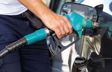 The gas station. A man refuels a car with gasoline. A Russian fuel dispenser in the fuel tank of a...