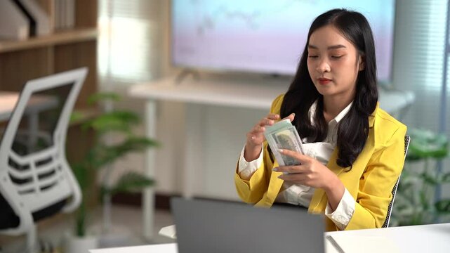 Asian businesses women working in the office used laptop and smartphone at her dest 
