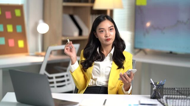 Asian businesses women working in the office used laptop and smartphone at her dest 