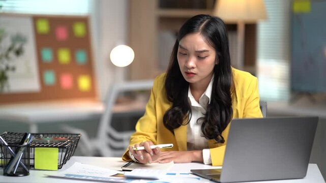 Asian businesses women working in the office used laptop and smartphone at her dest 