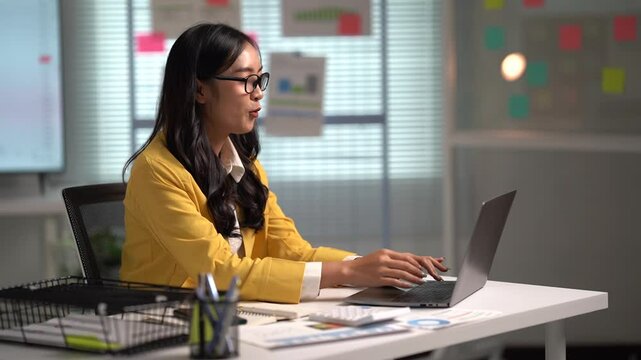Asian businesses women working in the office used laptop and smartphone at her dest 
