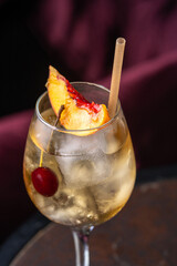 Peach cocktail in glass on dark background