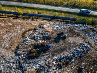 Garbage dump and working dump truck and bulldozer, aerial view