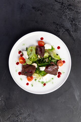 Beef salad in a plate. on a dark background.