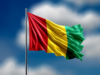 Guinea flag flying on blur blue clouds background.