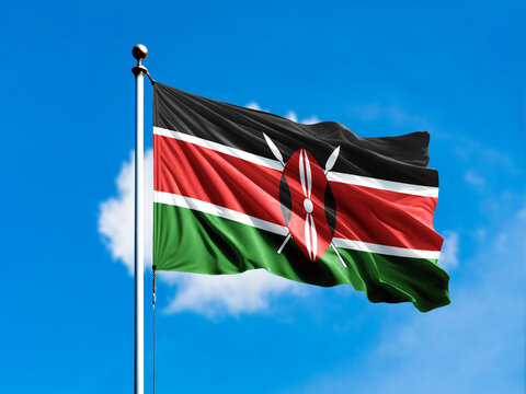 Kenya flag flying on blur blue clouds background.