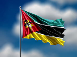 Mozambique flag flying on blur blue clouds background.