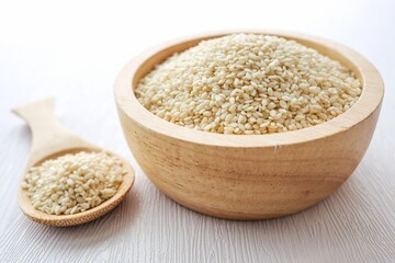 White Sesame Seeds in a wooden bowl with a wooden spoon on white background