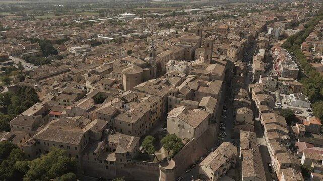 Aerial drone footage of Jesi, a charming Italian town with a well-preserved medieval borough, featuring narrow cobblestone streets, historic buildings, and the picturesque surrounding landscape