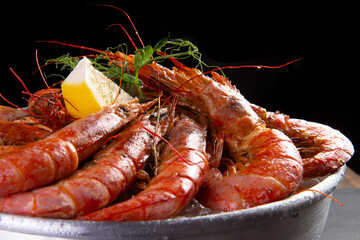 Large cooked shrimp on a dark background.
