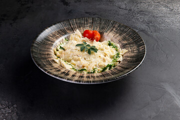Pasta in a plate on a dark background.