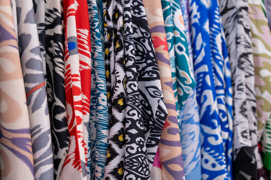 A row of colorful clothes with a variety of patterns and designs